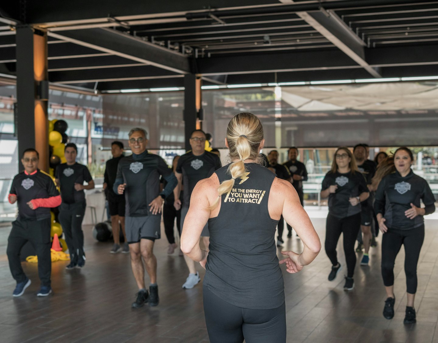 Instruktorka fitness prowadzi zajęcia w dopasowanych strojach sportowych na siłowni.